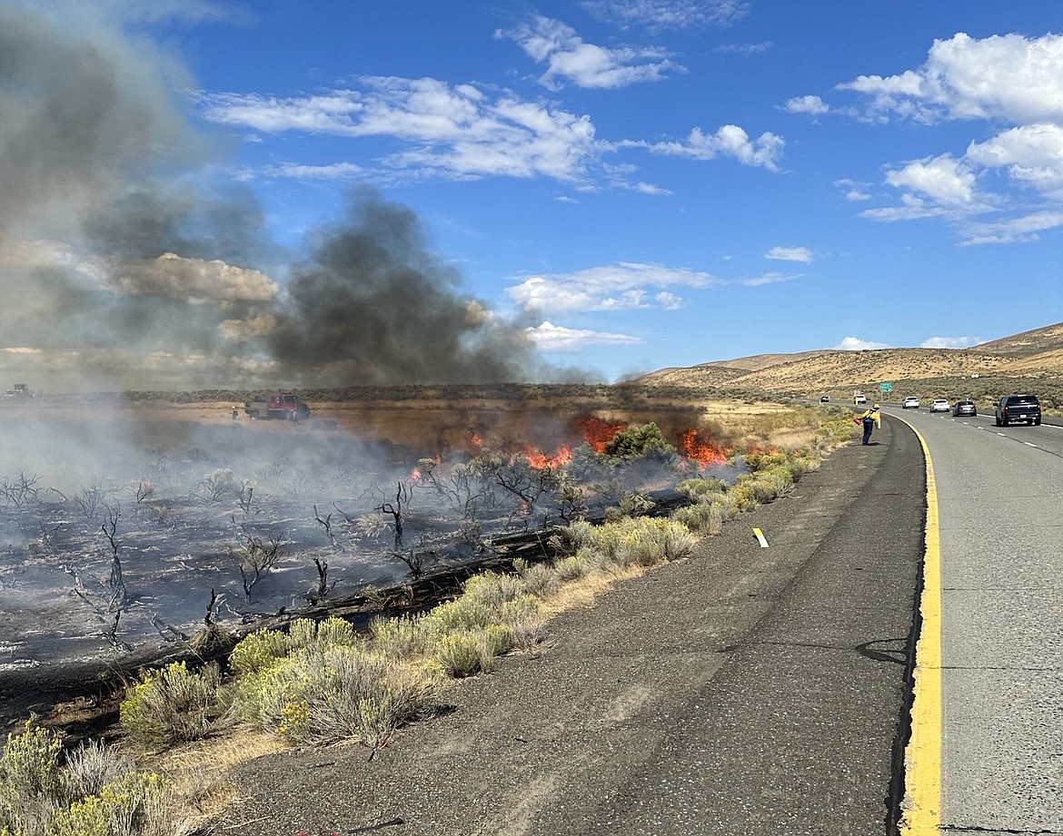 Flames and charred sagebrush mark the site of the Tendollar fire that was burning along I-82 Sunday.