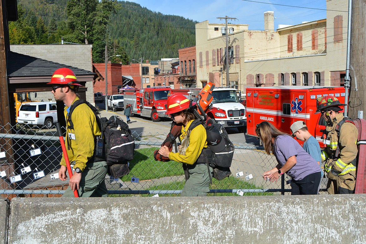Members of the U.S. Forestry Service carry their firefighting gear up the hill to begin the stair climb Monday.