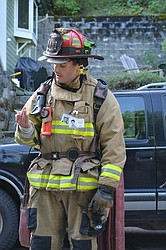 Victor Malsom of Shoshone Fire District One reads a snippet about the life of a fallen firefighter during the 9/11 memorial stair climb in Wallace.