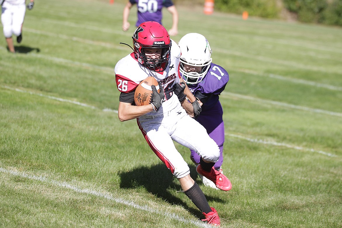 Kootenai sophomore running back Micheal Nyman attempts to break the tackle of Mullan-St. Regis junior defensive back Talon Rupp Connors during the first quarter of Friday's North Star League game at John Drager Field in Mullan.