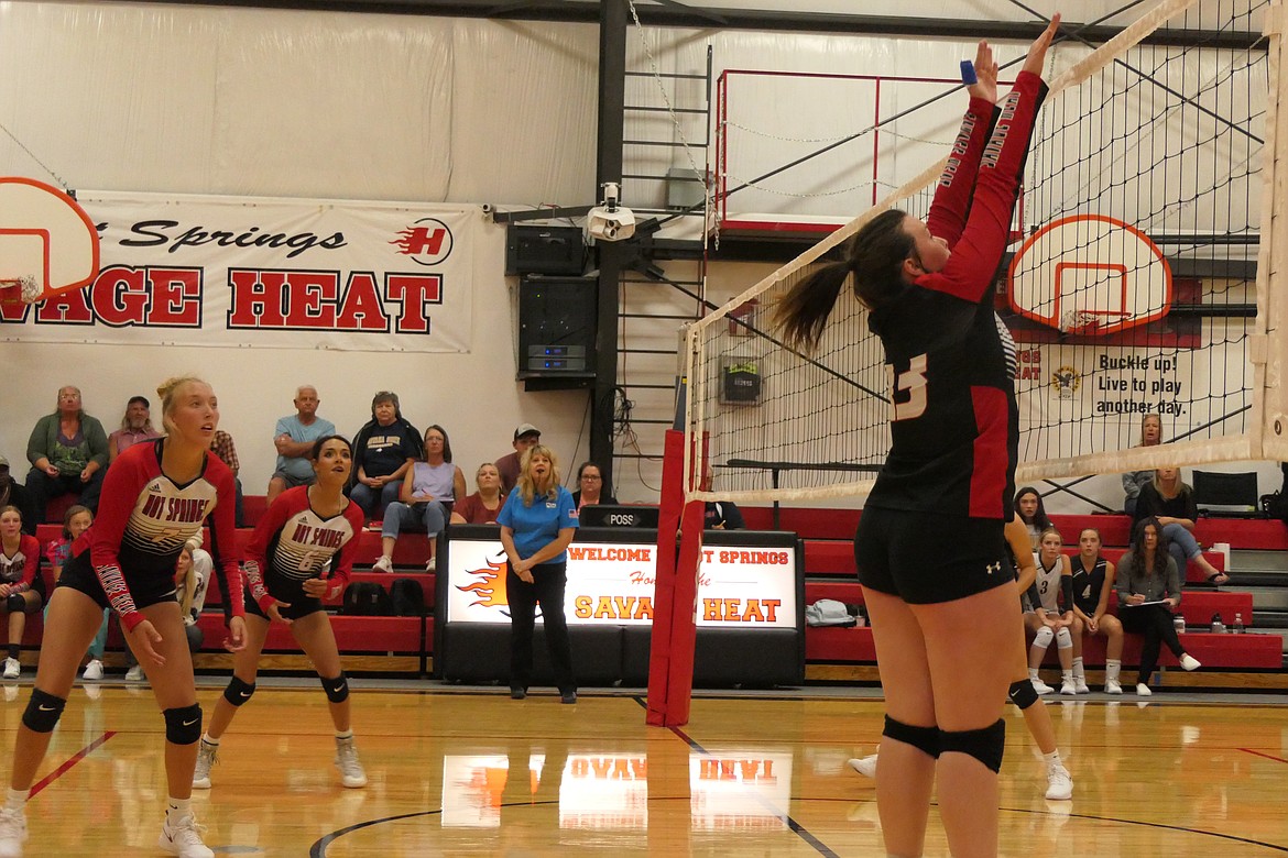 Hot Springs junior Brooke Jackson goes high to swat back a Seeley shot while teammates Lauryn Aldridge (7) and Jenna Heinrich (6) look on.  (Chuck Bandel/VP-MI)