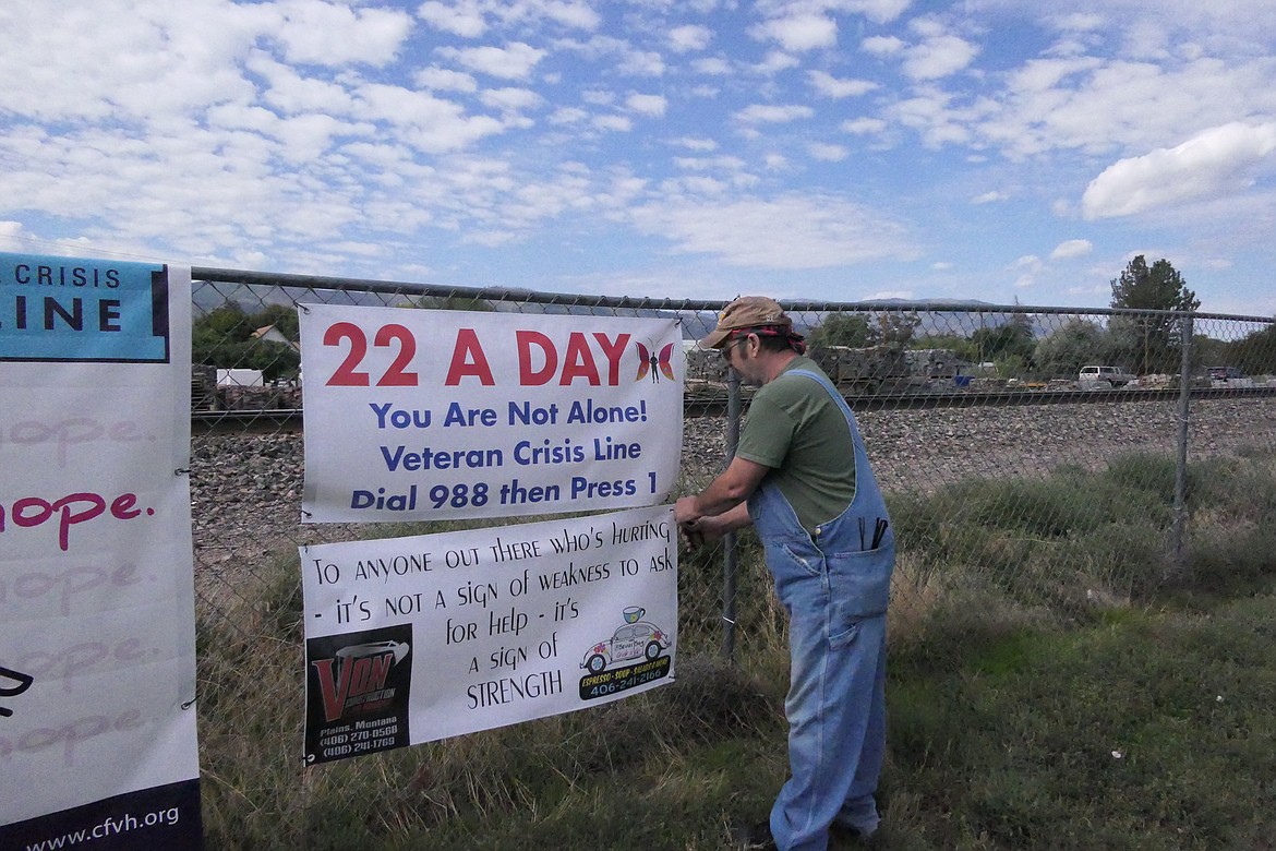 Local veteran Ed Foste straightens a banner that is part of a display he and other vets have put together to draw attention to the issue of suicide among veterans. (Chuck Bandel/VP-MI)