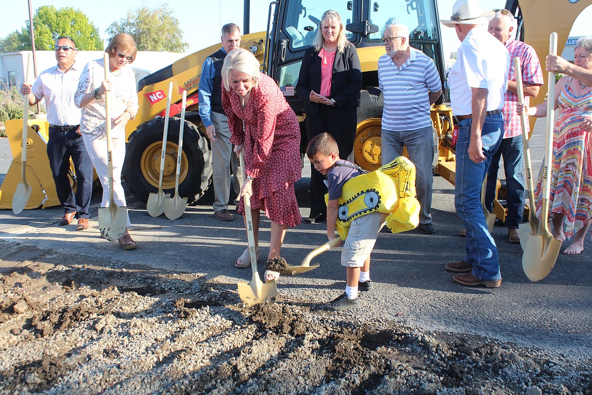 Quincy Valley Medical Center CEO Glenda Bishop, left, and Ezra Massey, right, turn some dirt at the groundbreaking ceremony for the new hospital Saturday.