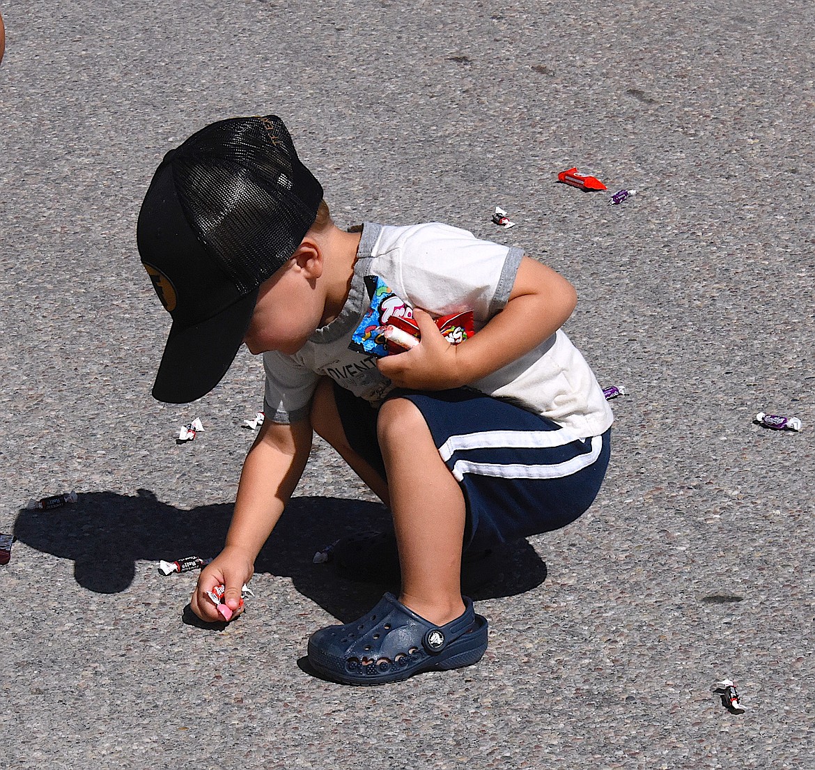 Eighteen-month old Tallon Fryberger collects candy as the Charlo Homecoming Parade goes by. (Berl Tiskus/Leader)