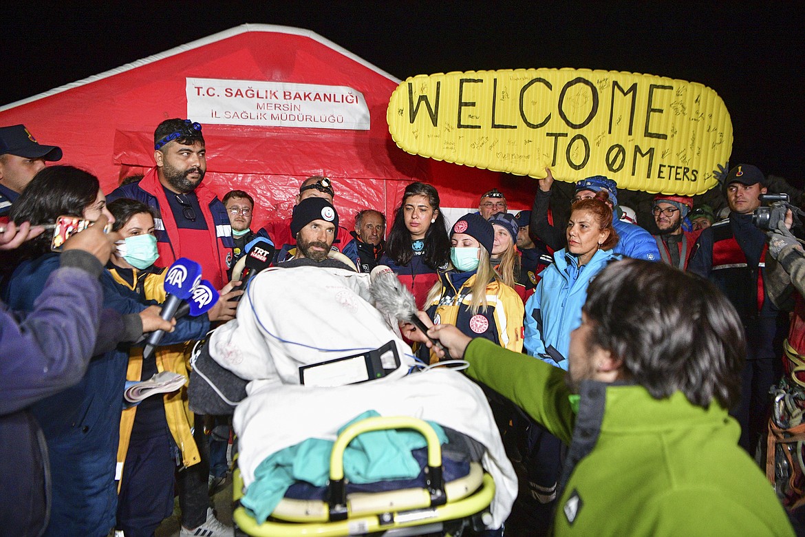 American researcher Mark Dickey, center, talks to journalists after being pulled out of Morca cave near Anamur, south Turkey, on early Tuesday, Sept. 12, 2023, more than a week after he became seriously ill 1,000 meters (more than 3,000 feet) below its entrance. Teams from across Europe had rushed to Morca cave in southern Turkey's Taurus Mountains to aid Dickey, a 40-year-old experienced caver who became seriously ill on Sept. 2 with stomach bleeding. (Mert Gokhan Koc/Dia Images via AP)