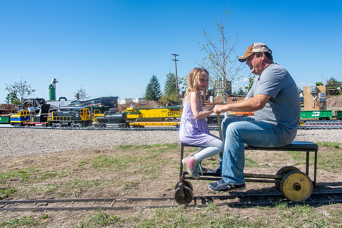 Faith and David Idleman ride a hand car along a miniature track at the show on Sept. 10.