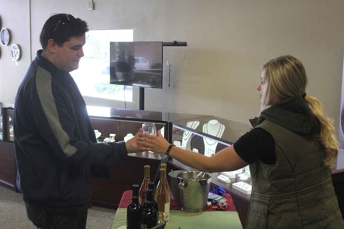 A customer stops for a sip at a previous Sip & Stroll event. Sip & Stroll 2023 is Saturday.