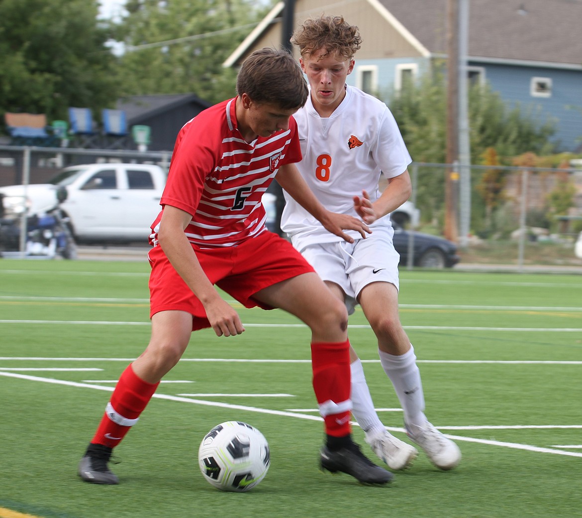 MAX OSWALD/Bonner County Daily Bee
Post Falls' Jacob Smith defends Sandpoint's Isaac Schmit deep in Trojan territory during Tuesday's Inland Empire League match at Memorial Field.