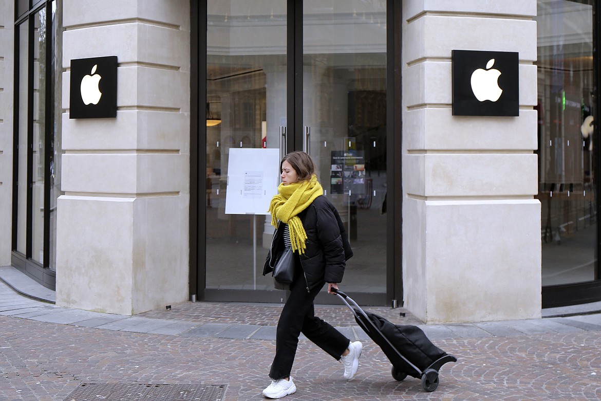 A woman walks past a closed Apple Store in Lille, northern France, Monday, March 16, 2020. A French watchdog ordered Apple to withdraw the iPhone 12 from the market because it is emitting too high levels of electromagnetic radiation. The National Frequencies Agency (ANFR), the body monitoring public exposure to radiations, called on Apple to "implement all available means to rapidly fix this malfunction," in a statement released on Tuesday Sept.12, 2023. (AP Photo/Michel Spingler, File)