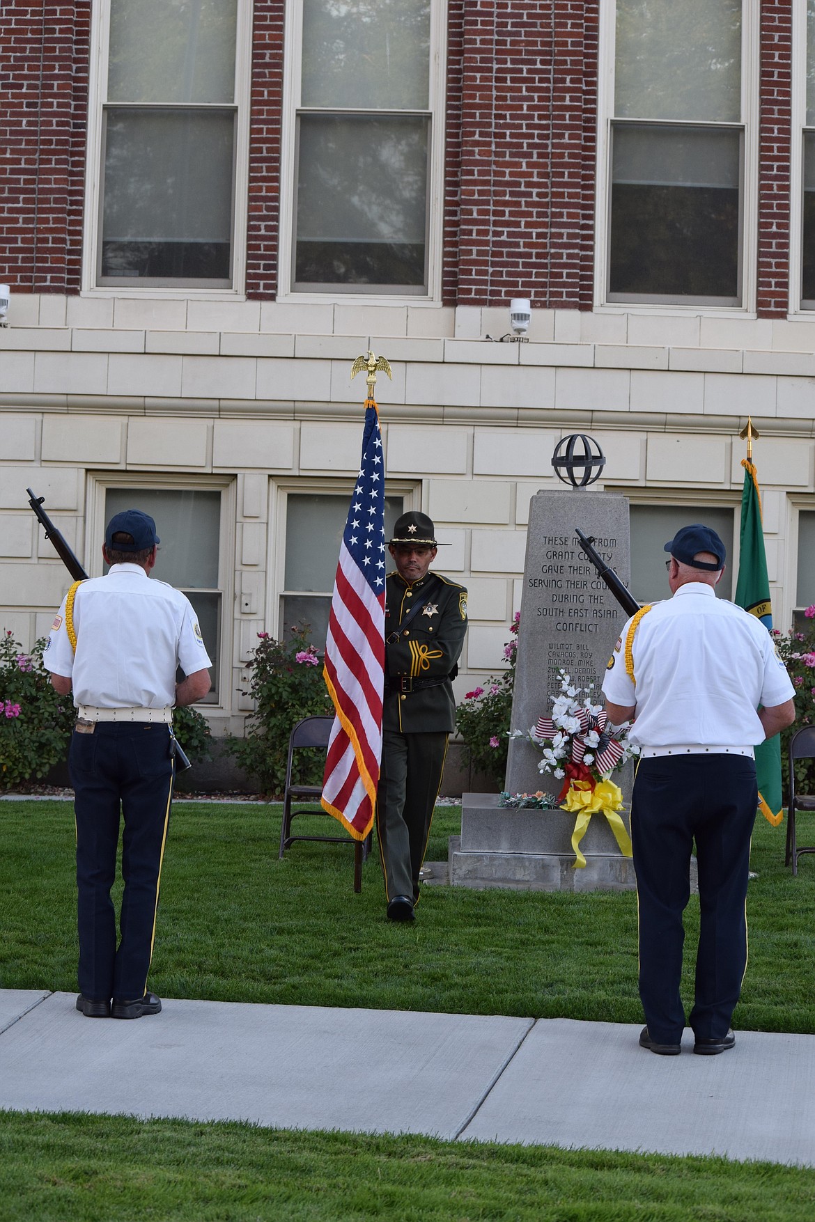 A Grant County Sheriff’s Office officer performs his duties as part of the honor guard Monday, flanked by Legionnaires from the Ephrata American Legion post’s honor guard.