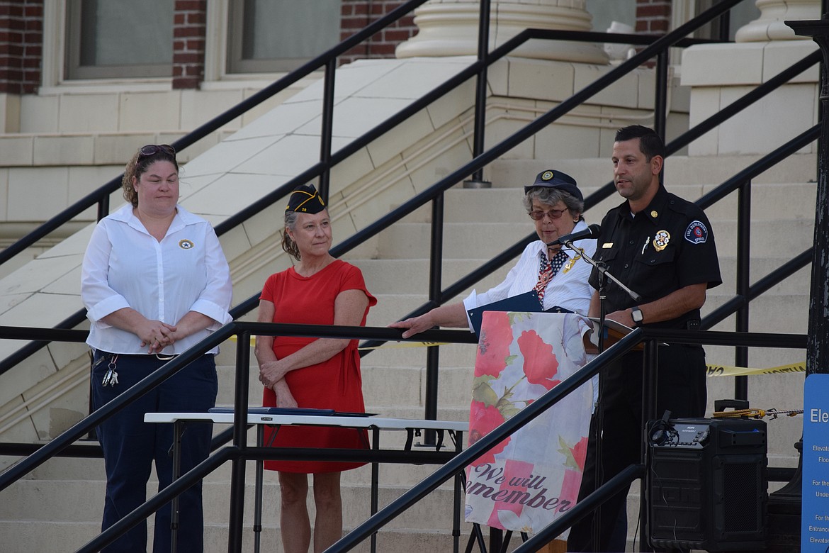 Members of the Ephrata American Legion Post Auxiliary stand in the background as Ephrata Fire Chief Jeremy Burns delivers comments.