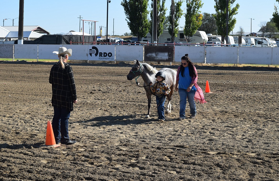 Judge Genny Miller, left, watches as June Hammer and Katie Hammer compete in the Halter and Showmanship event at the Othello Fair Wednesday morning.