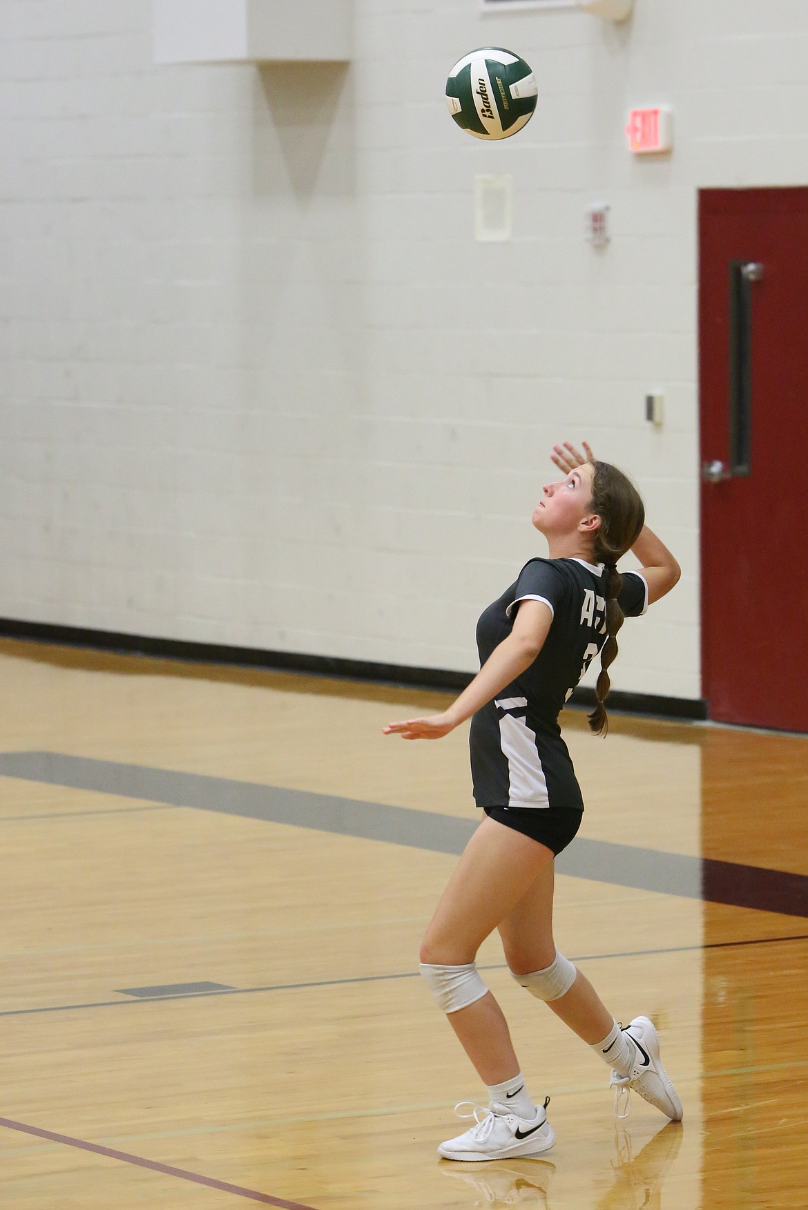 Almira/Coulee-Hartline junior Emma Whitaker looks up at the ball before serving against Waterville-Mansfield.