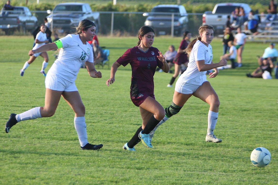 Wahluke freshman Ashya Erazo (4) runs upfield past two Quincy defenders during a game against the Jacks on Sept. 7.