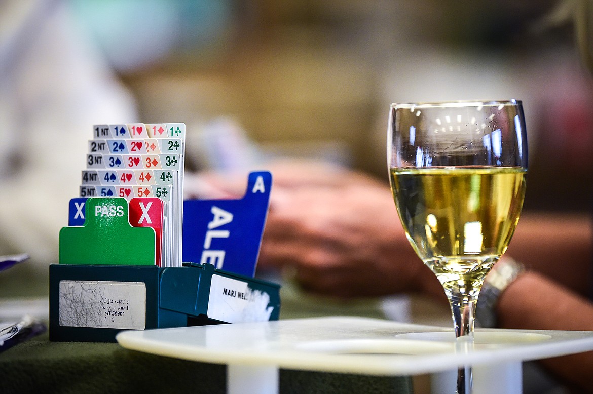 A glass of wine accompanies a bidding box as players play a game of bridge at the Flathead Valley Bridge Center in Kalispell on Friday, Sept. 25. (Casey Kreider/Daily Inter Lake)