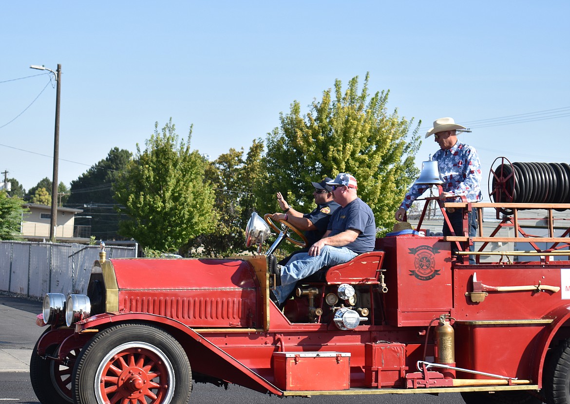 Othello Parade Grand Marshal Anthony Dailey, right, prepares to toss a cowboy hat into the crowd of youngsters lining Main Street Saturday morning.