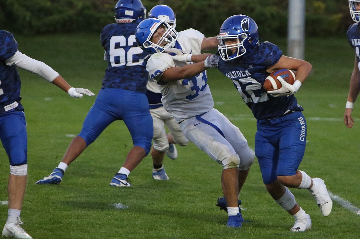 Warden junior Elijah Ruiz stiff-arms a Kiona-Benton defender on the Cougars’ opening drive of the game.