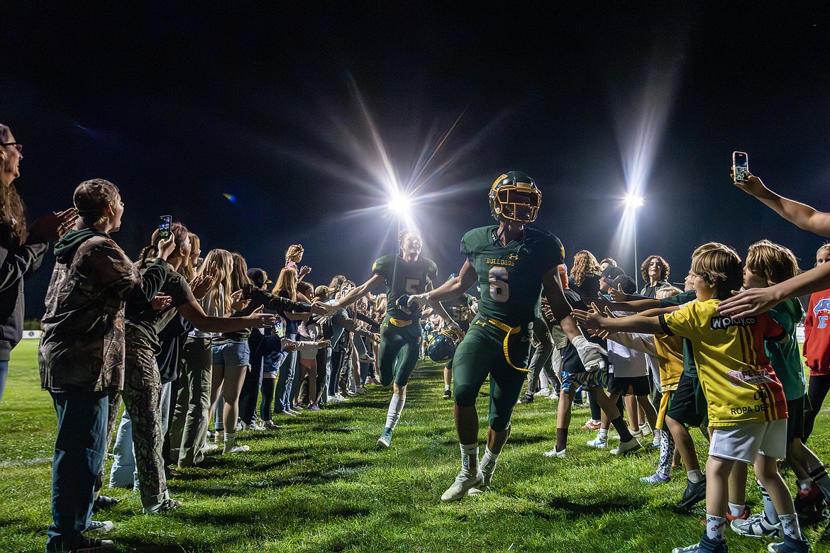 Jesse Burrough (5) and Ryder Barinowski (6) are cheered on by Bulldogs fans flooding the field after Whitefish’s overtime victory over Columbia Falls, 20-14.