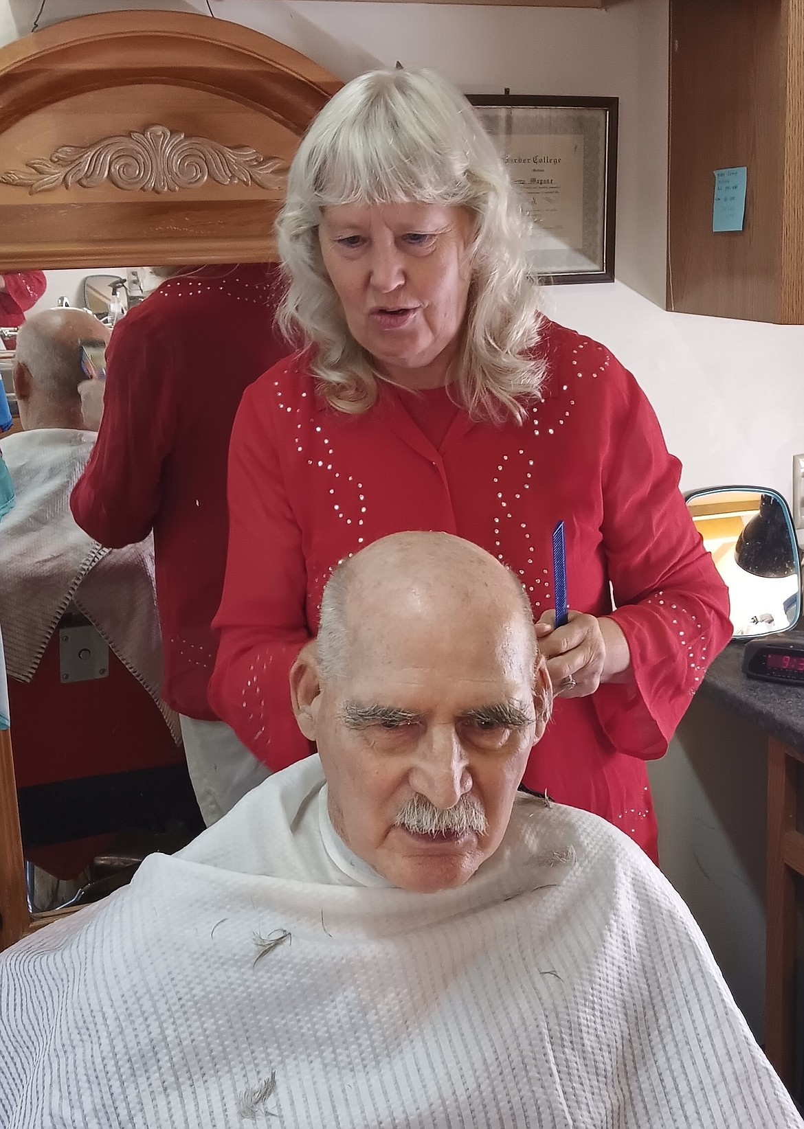 Becky Magone cuts Richard Dent’s hair recently at Becky’s Superior Cuts in Superior. With Magone retiring Sept. 30, Mineral County will no longer have a commercial barber shop. (Monte Turner/Mineral Independent)