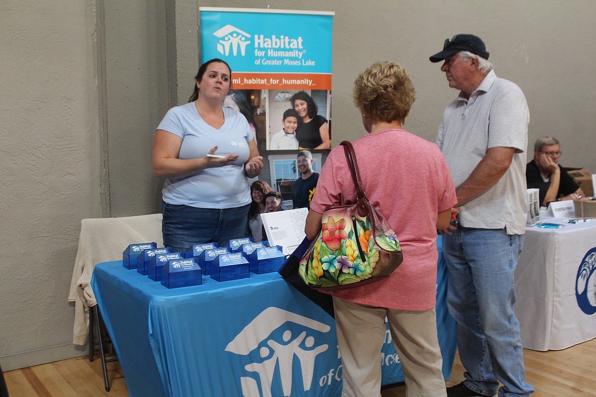 Rebecca Mabius, left, talks with people about the services available through Habitat for Humanity of Greater Moses Lake at the Care Fair Saturday.