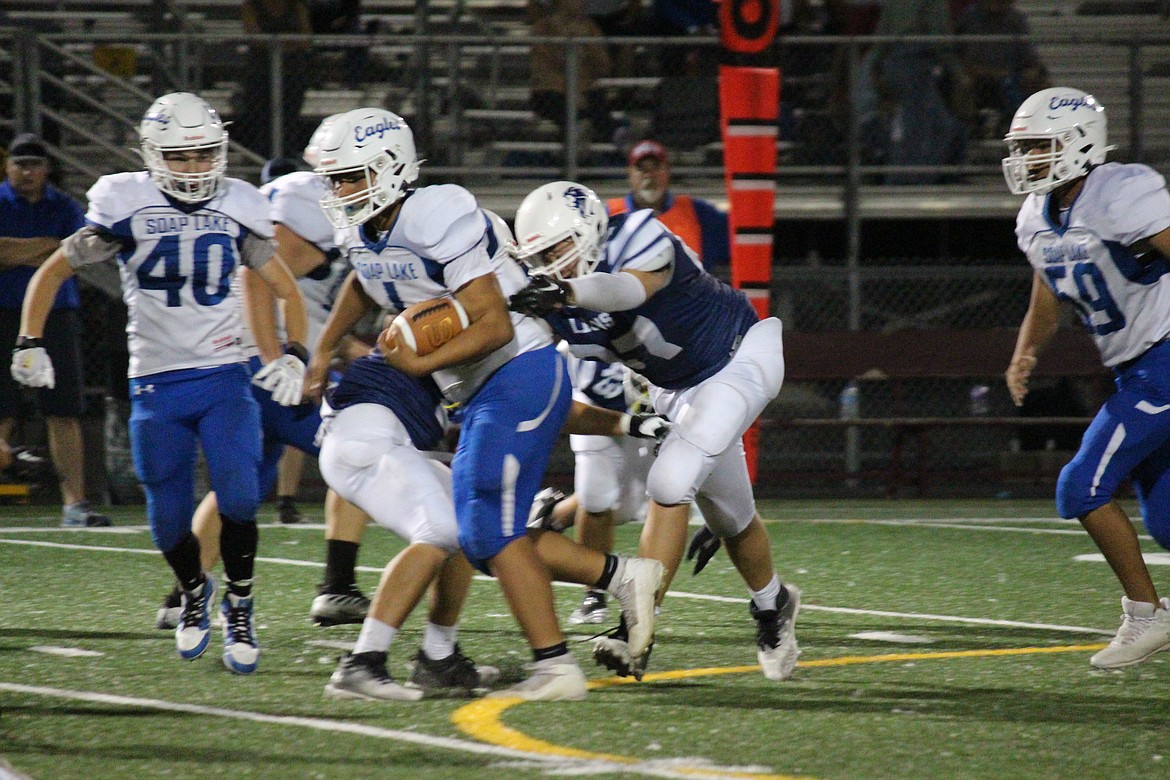 Soap Lake quarterback Jairo Lopez (4) escapes the grasp of a MLCA/CCS defender.