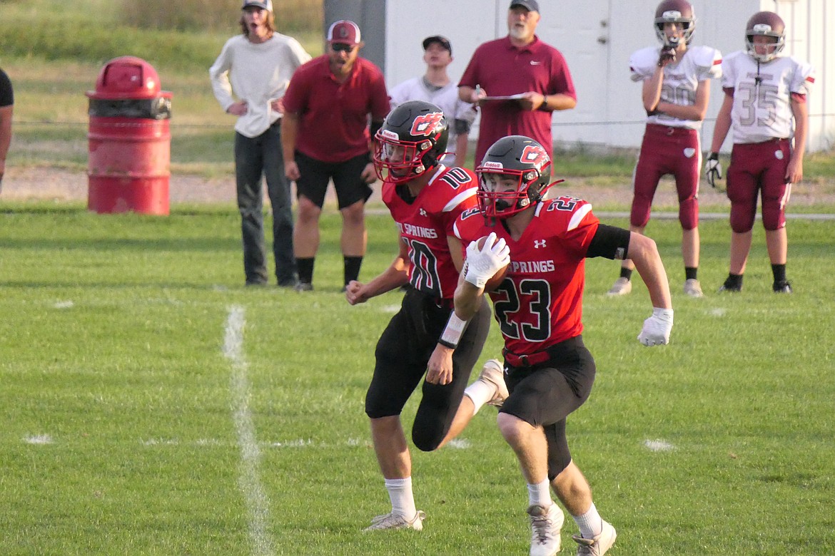 Savage Heat junior John Waterbury (23) gets blocking help from Hot Springs' Nick McAllister during first quarter action of their game vs Alberton this past Monday in Hot Springs. (Chuck Bandel/VP-MI)