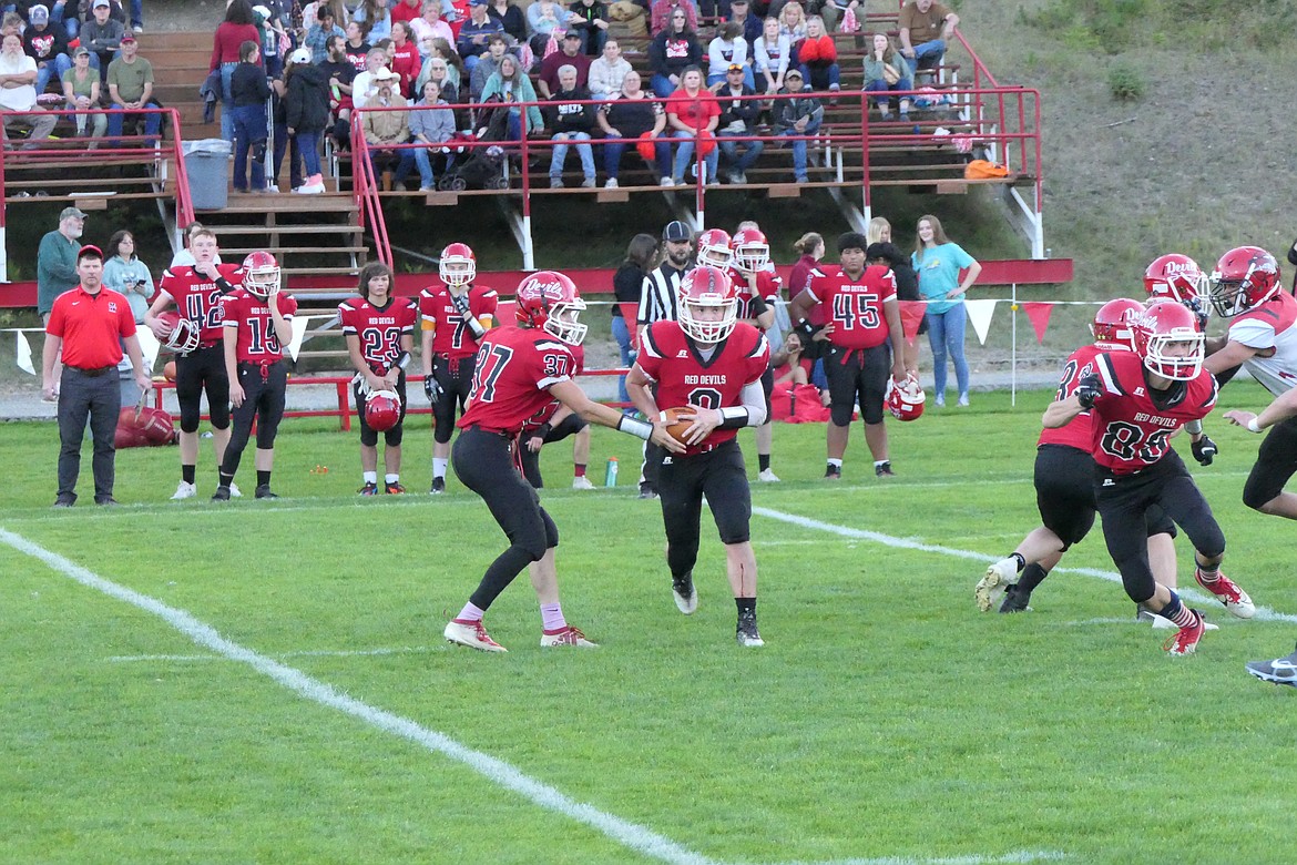 Noxon quarterback Brian Risch hands off to running back Shamus Wheeldon during their game against West Yellowstone Friday night in Noxon.  (Chuck Bandel/VP-MI)