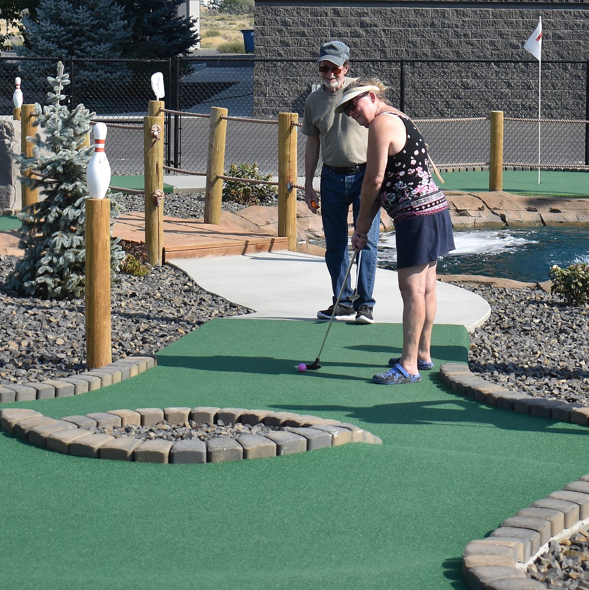 Glenna Killinger lines up a putt on the 13th hole at the Ten Pin mini-golf course Saturday. Her favorite hole is the 12th, she said, because of the water shot.