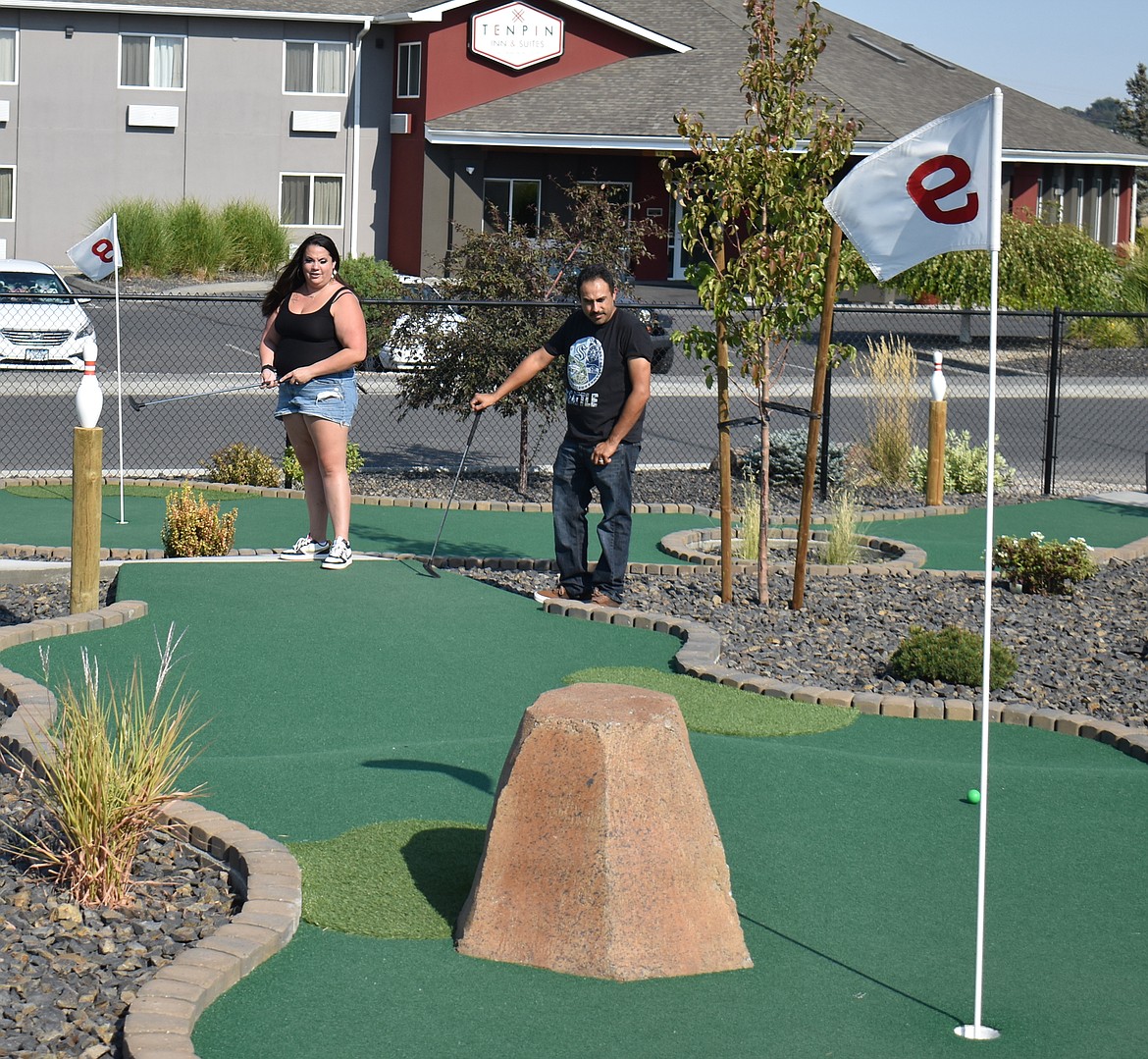 Brittany Aguinaga and her husband Jose Aguinaga of Moses Lake plan their strategy at the Ten Pin mini-golf course. The Aguinagas were having a little grownup time Saturday while their children were at a birthday party at Lake Bowl.