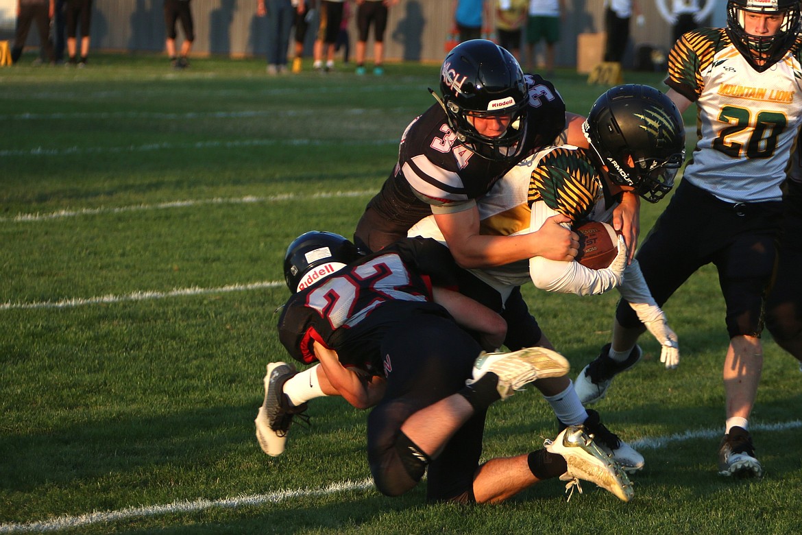 ACH senior Everett Wood (34) and sophomore Harvest Parrish combine for a tackle against Liberty Bell on Saturday.