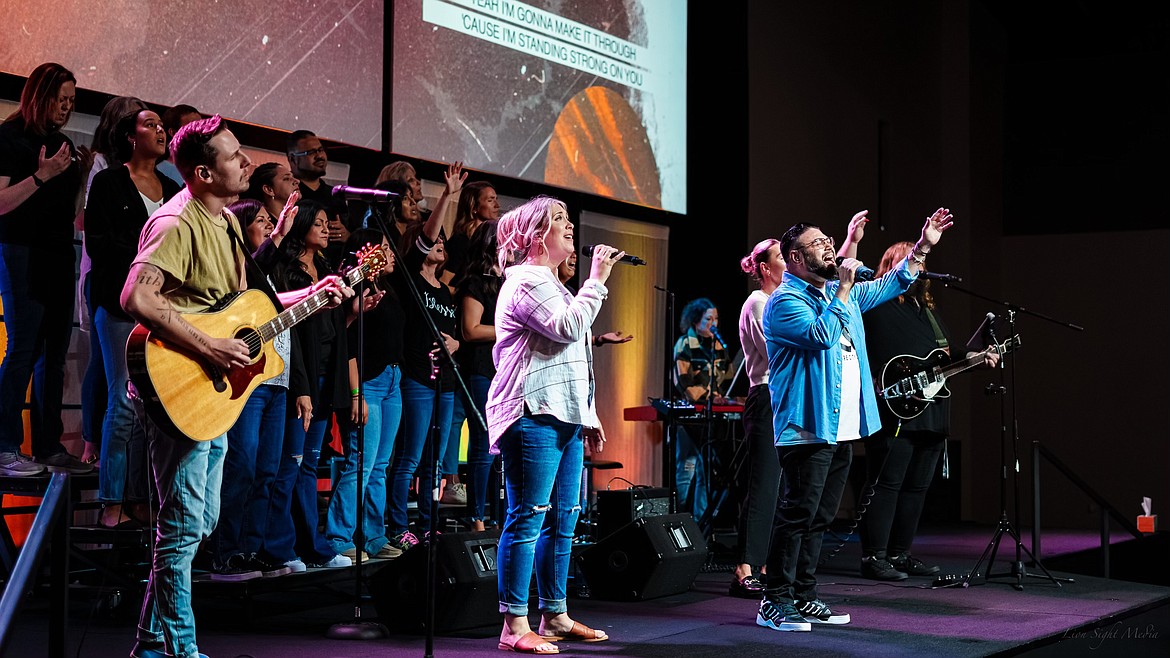 Jon White, worship pastor at Moses Lake Presbyterian Church, Ekko Nash of Restore City Church, Restore City Church Worship Pastor Jim Balli and a choir consisting of members of multiple churches in Moses Lake and Ephrata worship on stage at the United Community Worship Night Friday at Restore City.