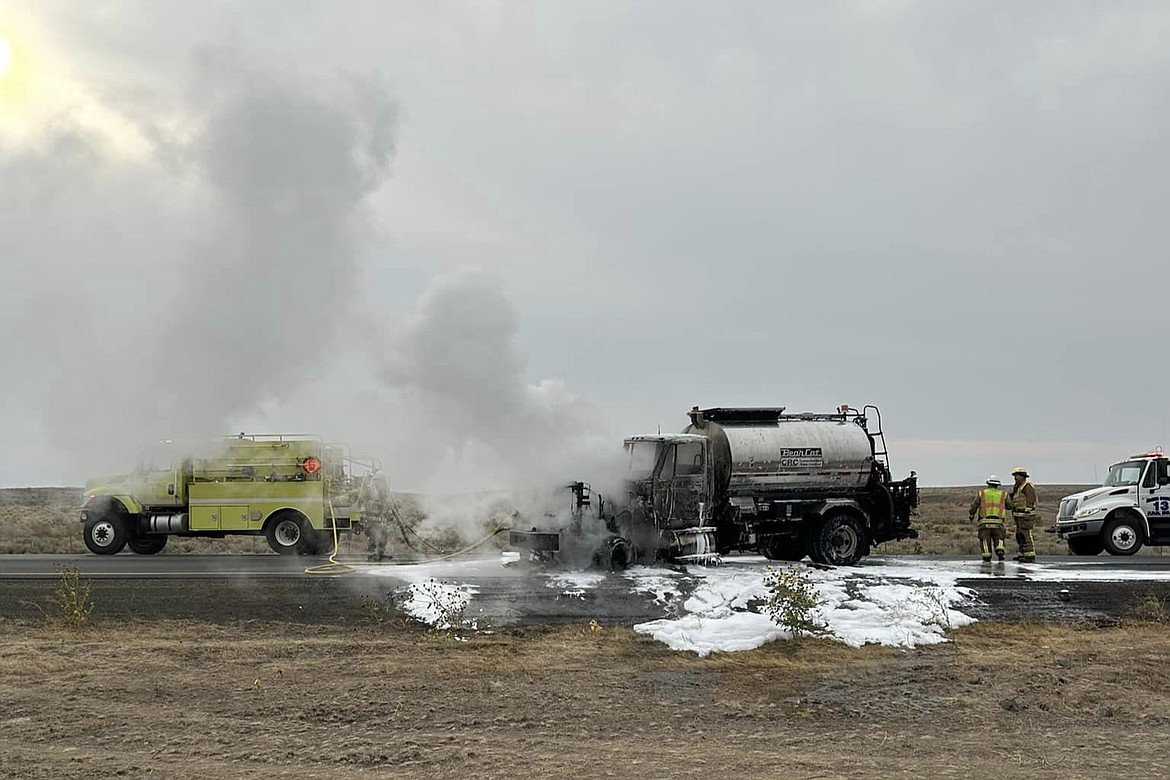 Firefighters attend to an allegedly stolen Washington Department of Transportation asphalt truck that caught fire during a vehicle pursuit on State Route 26, State Route 261 and Interstate 90.