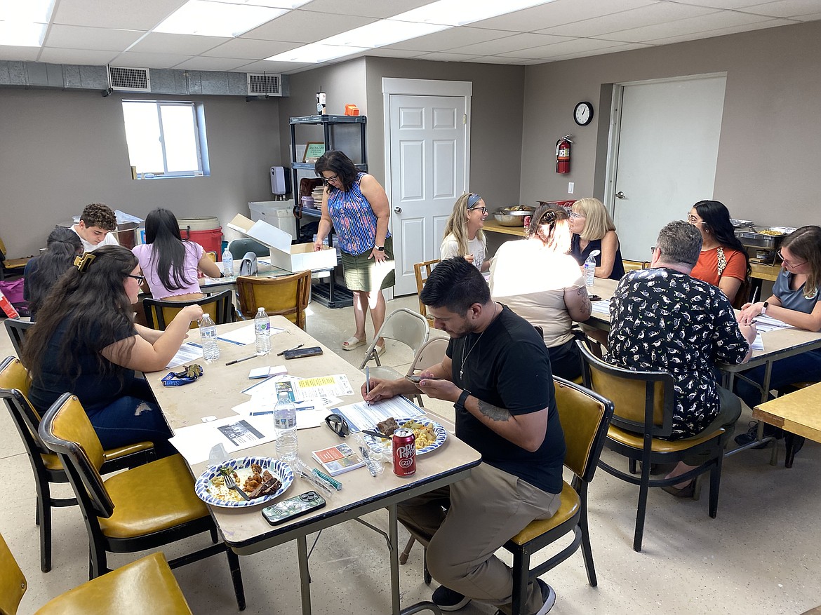 Participants in an Elevate Othello luncheon write down and discuss their ideas for the town’s future.