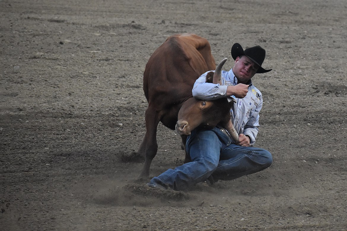 A steer wrestler attempts to twist over a steer at the Moses Lake Roundup on Aug. 19.