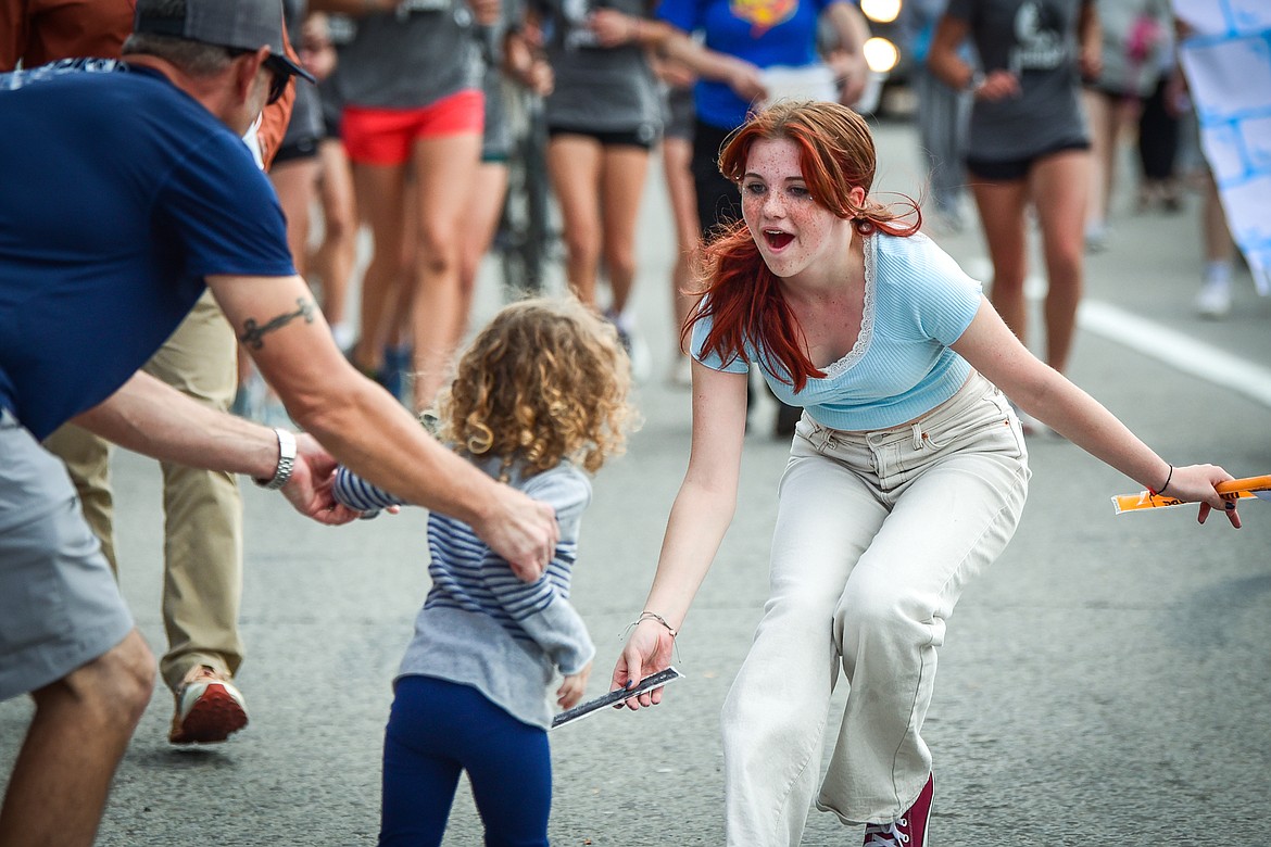 Members of the parade procession hand out candy to children during the Flathead High School Homecoming Parade along Main Street in Kalispell on Wednesday, Sept. 20. (Casey Kreider/Daily Inter Lake)