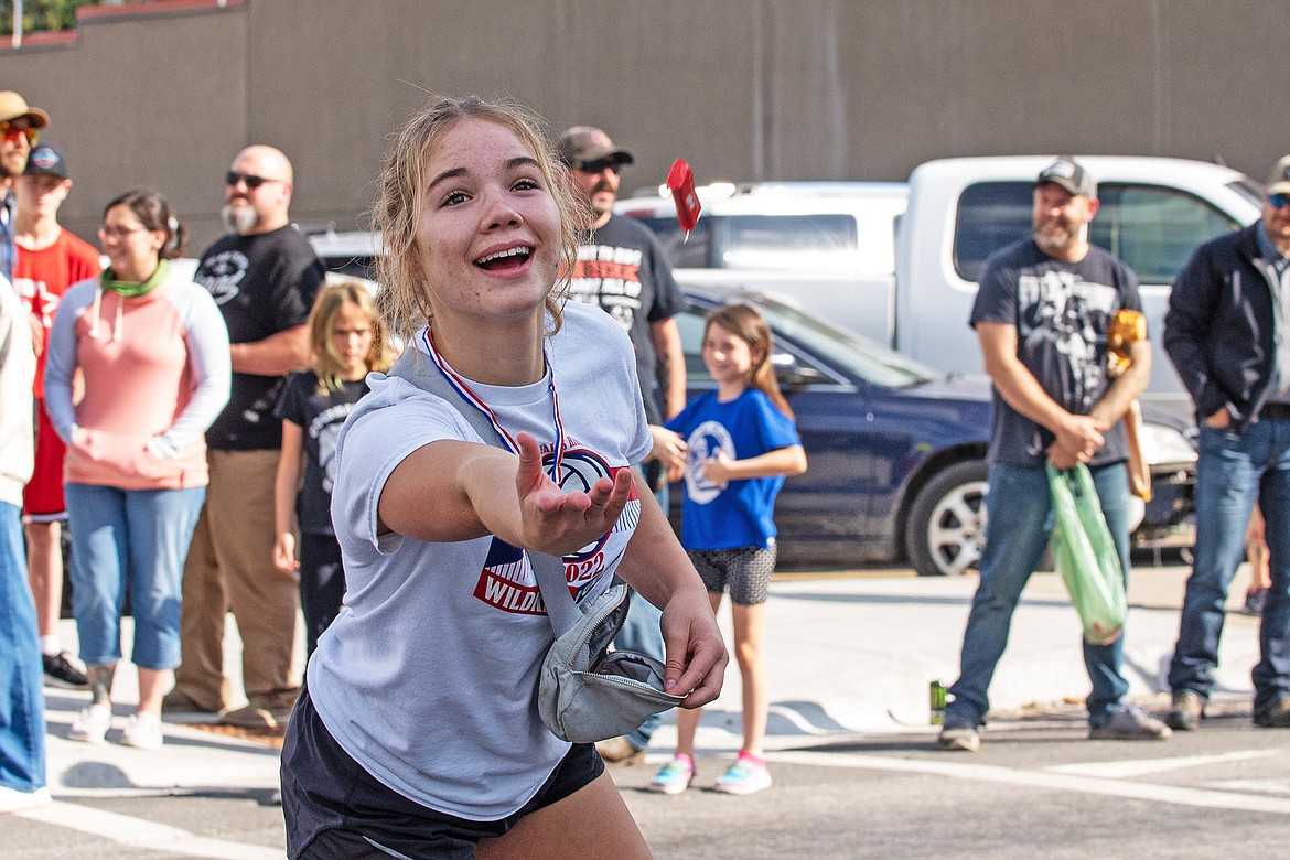 Wildkats volleyball libero Lucy Love tosses candy to a spectator at the 2023 Homecoming Parade.
