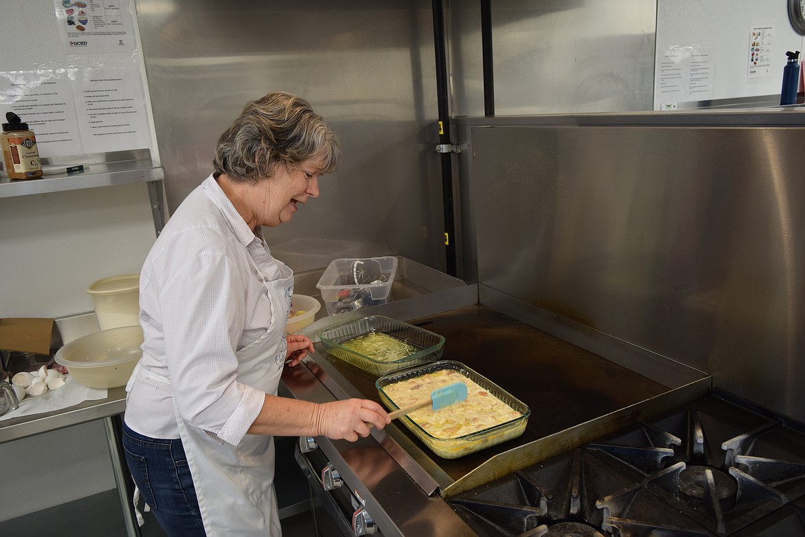 Kim Helvy prepares bread pudding for dessert Sept. 7 in the kitchen of Our Lady of Fatima Catholic Church in Moses Lake, while the volunteer kitchen team members prepare for the hot lunch they provide every Thursday.