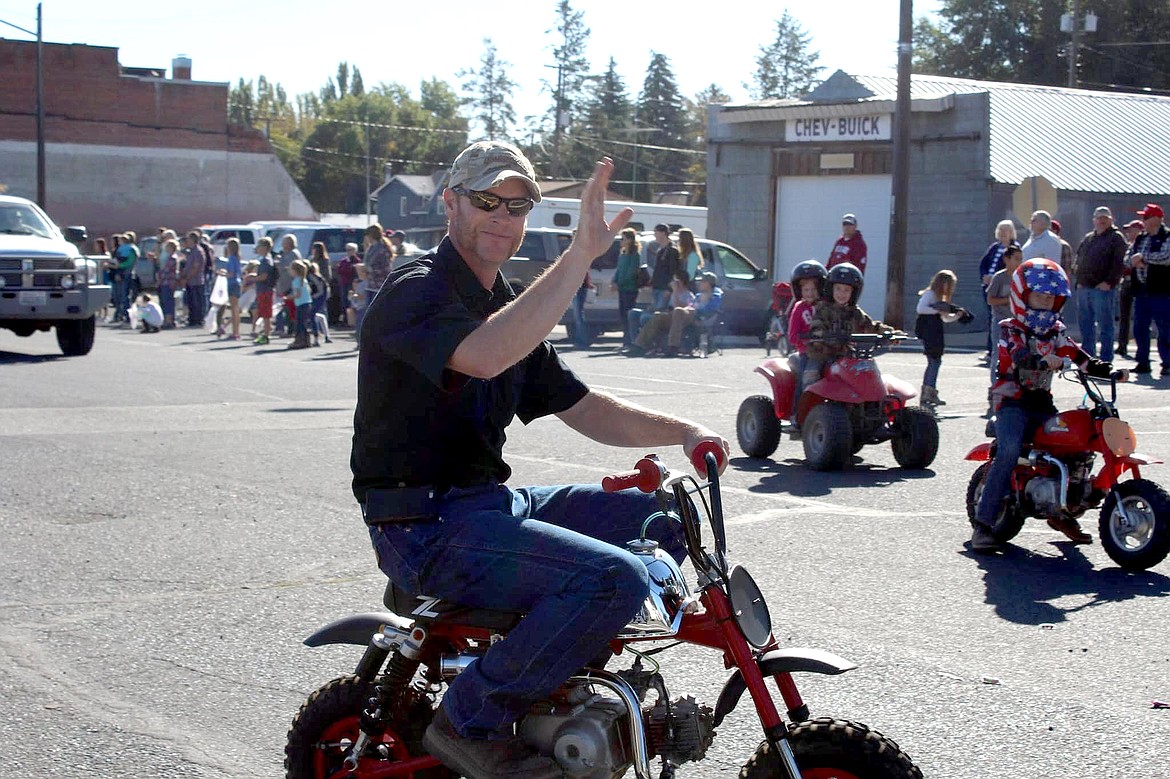 Ryan Peha of Almira waves as he rides his minibike in a past Almira Country Fair parade. Alongside him, from left, are his children Cameron and Quinn on the four-wheeler and Adyn on the minibike.