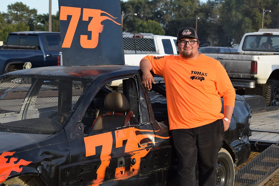 Tomas Pruneda stands next to his car in the pit area outside the rodeo arena at the Adams County Fairgrounds after competing in his time trial at the Othello Demolition Derby Sept. 13.