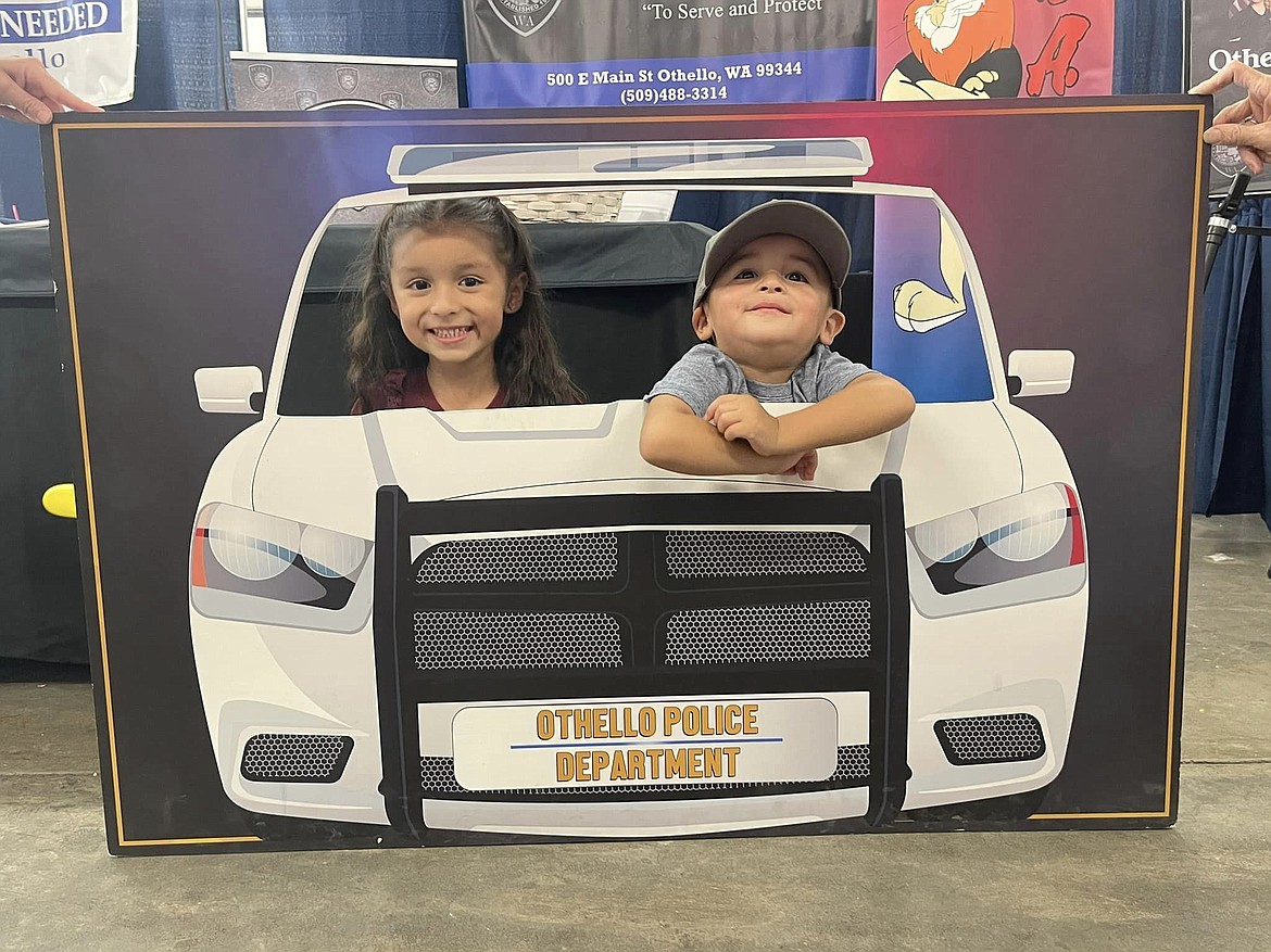 Could they be considered juvenile officers? Two potential future police pose for a photo in the patrol car at the Othello Police Department booth at the Othello Fair last week.