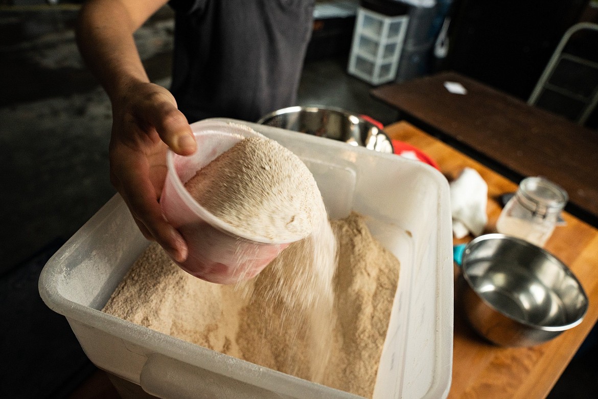 Caroline Garrett measures out ingredients as she makes bread for her business Sourdough Pursuit. (Photo courtesy of Kyle Stansbury Photography)