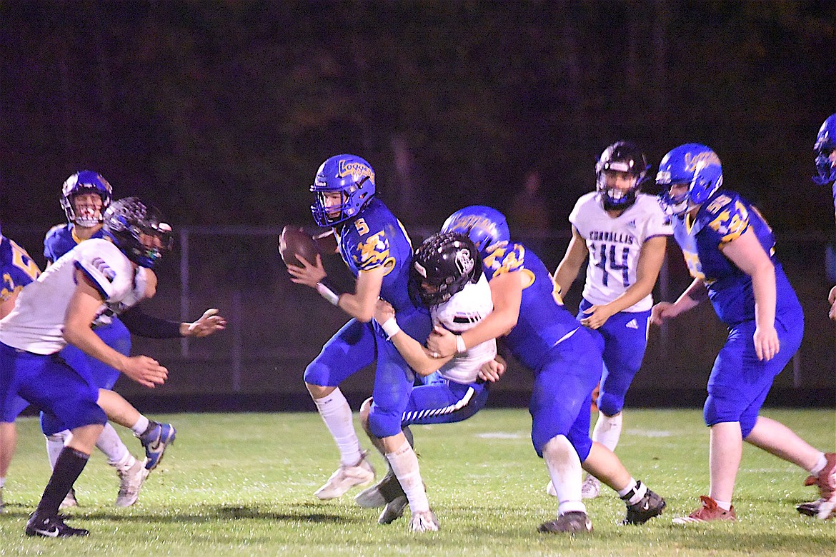 Libby Loggers quarterback Tristan Andersen tries to get free from a Corvallis tackler in the Friday, Sept. 22 game. (Scott Shindledecker/The Western News)