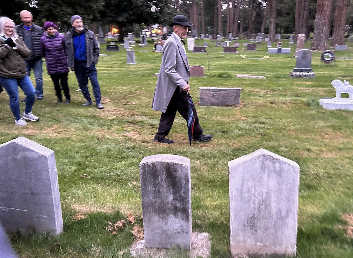 Dave Eubanks leads a group past headstones at Forest Cemetery on Friday.