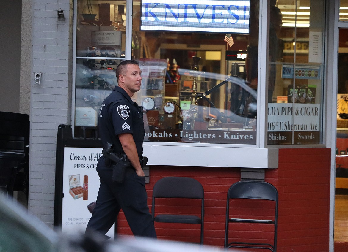 Police Sgt. Joseph Scholten surveys downtown as he walks on Sherman Avenue on Friday.