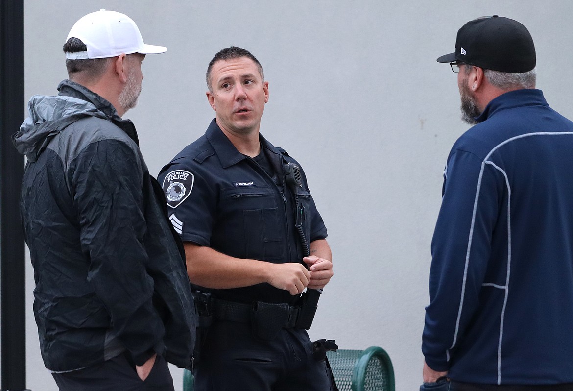 Sgt. Joseph Scholten talks with two visitors on Sherman Avenue on Friday.