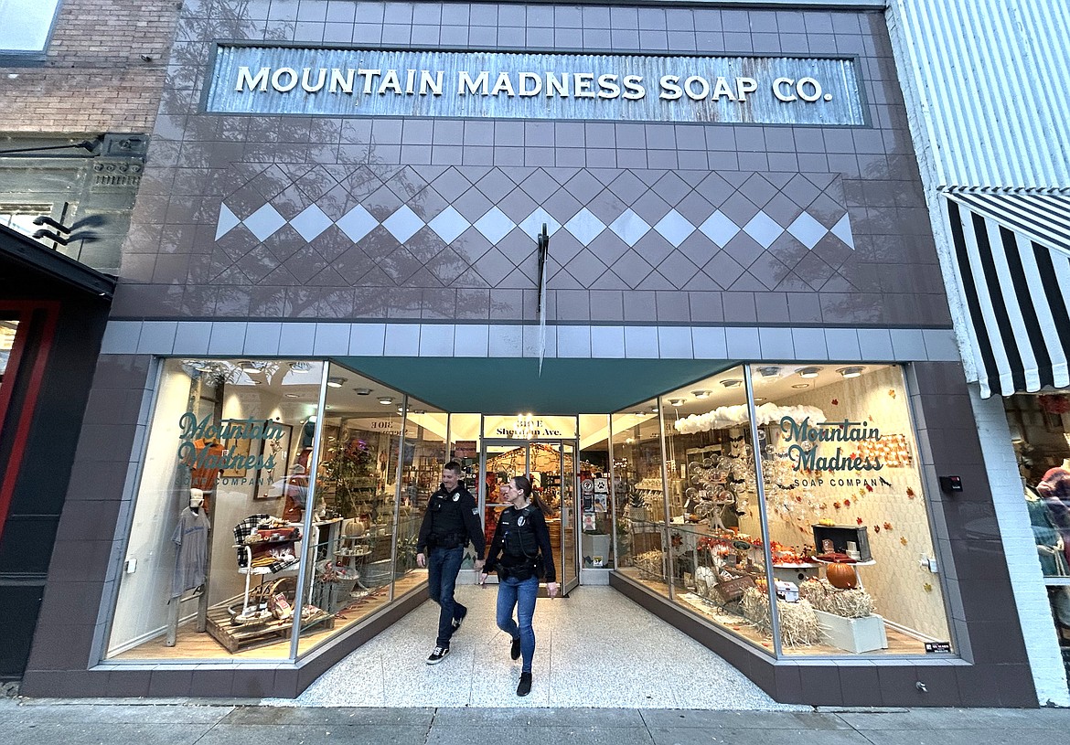 Police officers Derrick Vachon and Amelia Thompson walk out of Mountain Madness Soap Co. on Sherman Avenue after visiting with staff Friday.