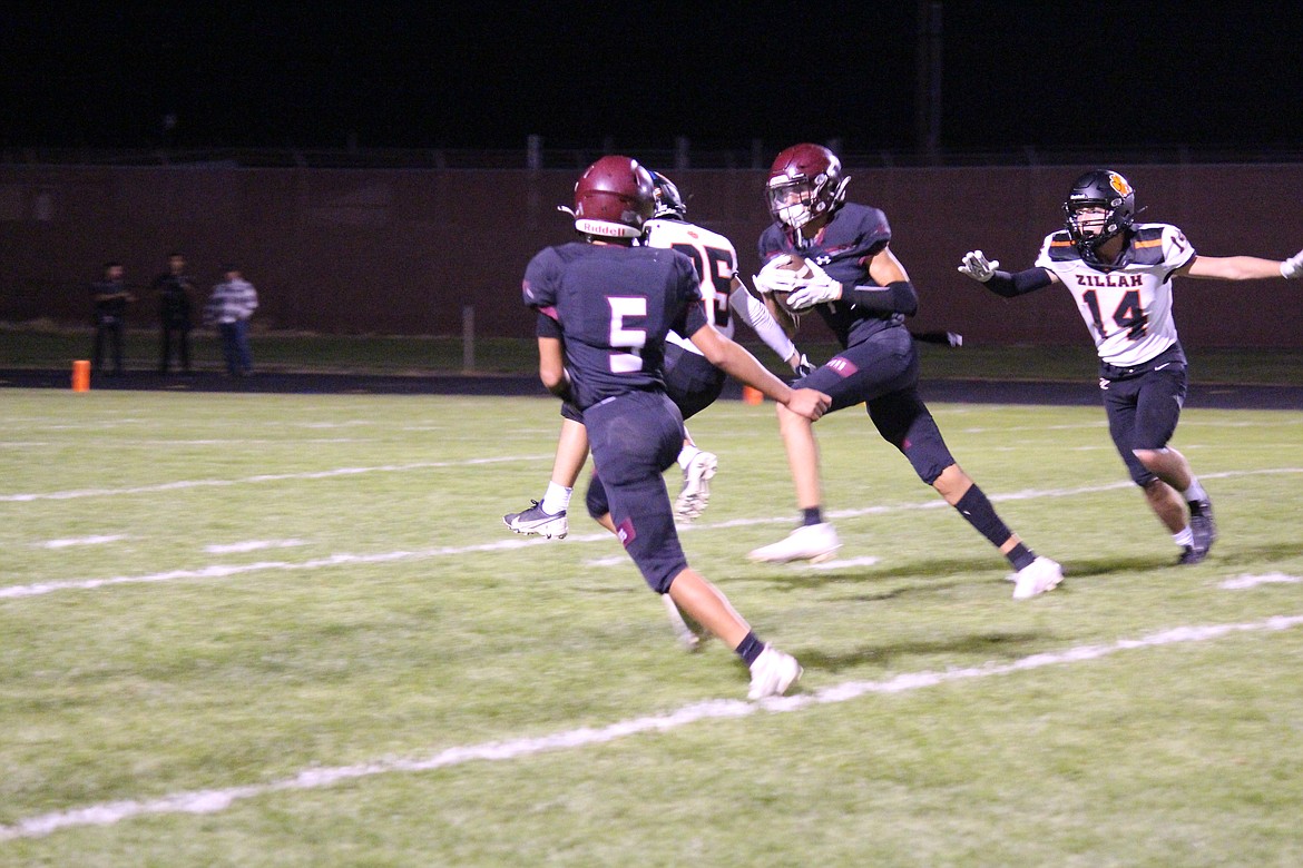 Kacey Hirai, center, comes down with the pass that led to a Wahluke touchdown in the Warriors’ 48-7 loss to Zillah Friday.