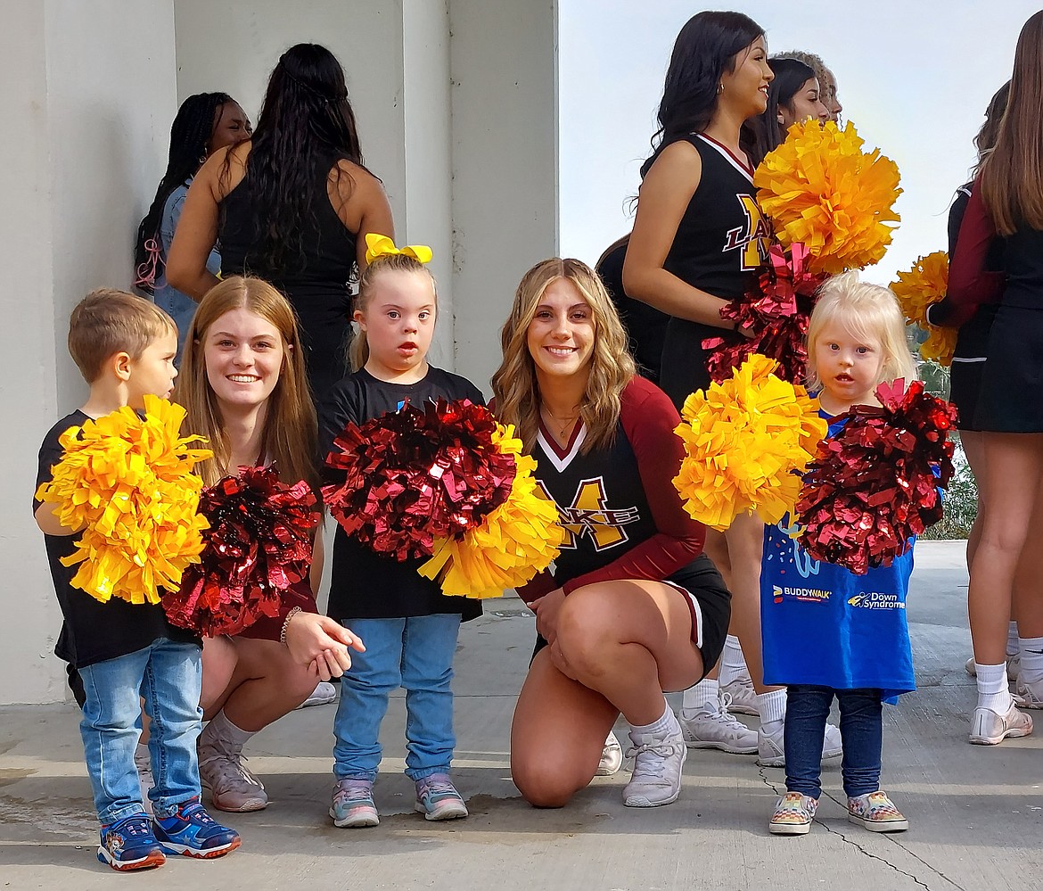 Two Moses Lake High School cheerleaders pause for a photo and some smiles with three children with Down syndrome at the Buddy Walk Saturday.