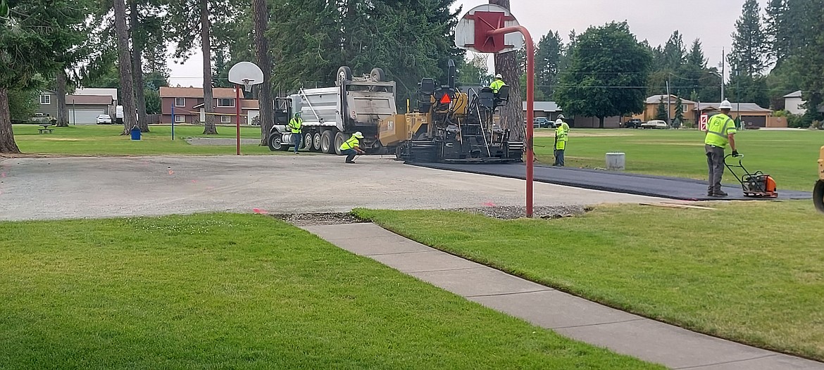 Construction workers pour the asphalt for the new basketball court at Stub Myers Park. The court was a grant funded project to replace the existing cracked and puddled court.