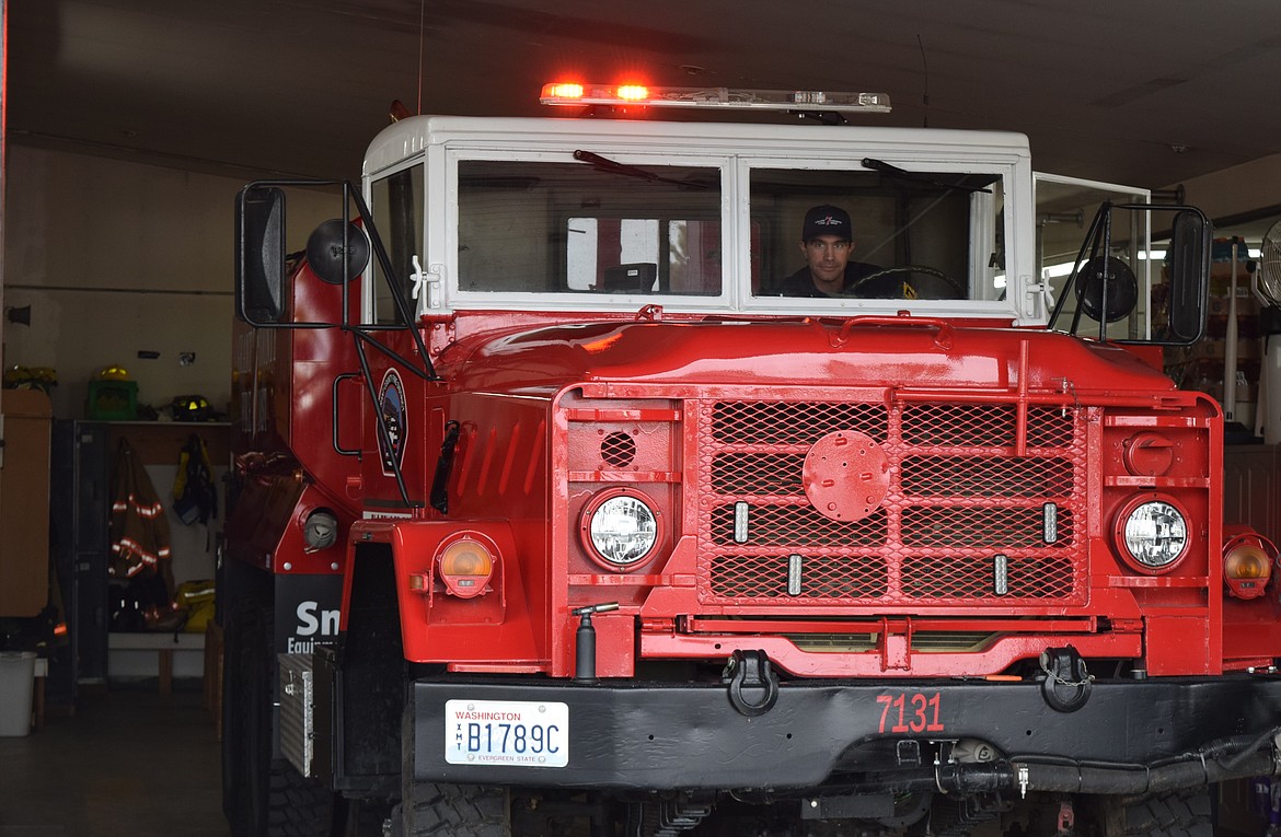 A Grant County Fire District 7 volunteer during Saturday’s open house flashes the lights on a repurposed military truck the department uses as a support vehicle.